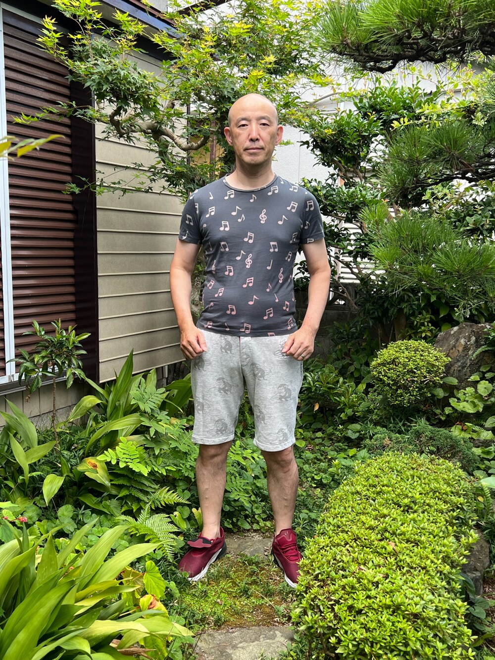 グリーン系のTシャツ/カットソー、シルバー系のパンツ、レッド系のスニーカーを着用したメンズの夏コーディネートの2枚目の写真