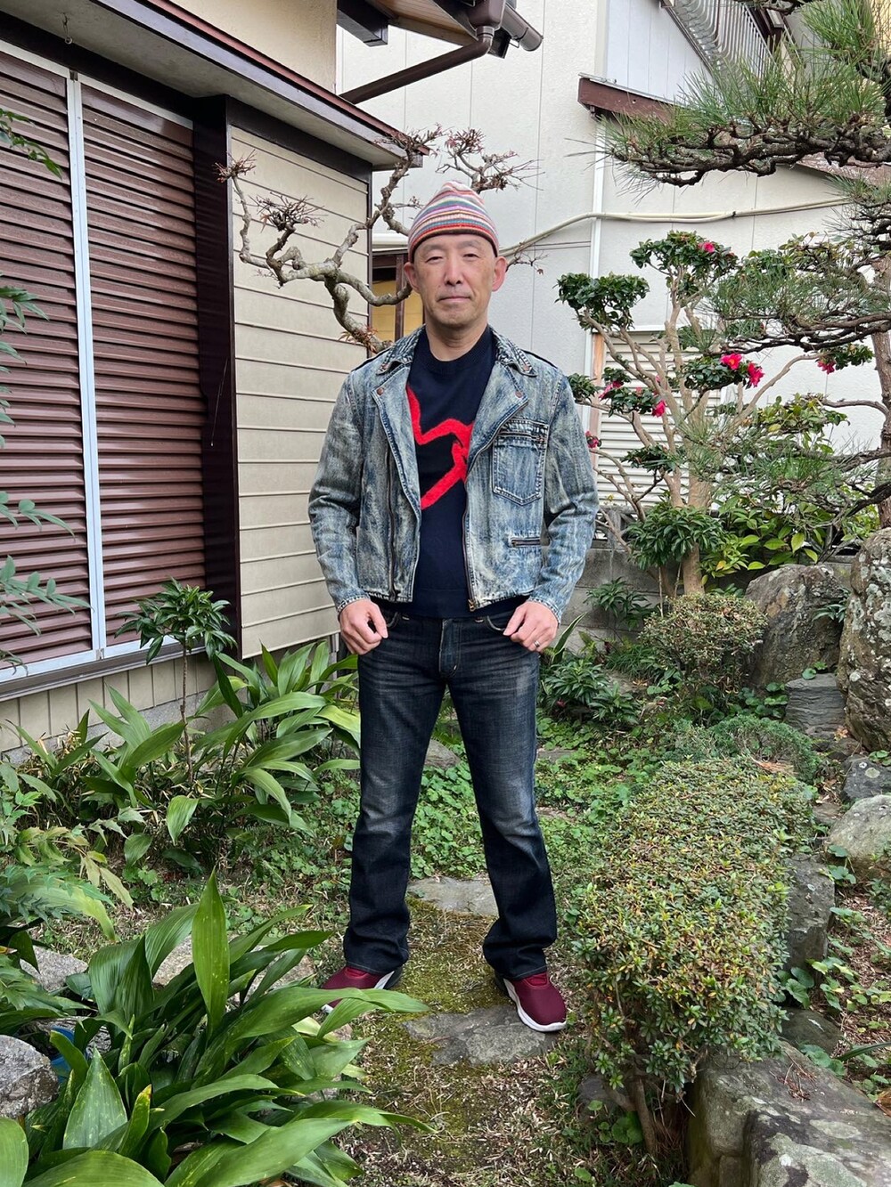 ブラック系のニット/セーター、ブルー系のライダースジャケット、ブラック系のデニムパンツを着用したメンズの冬コーディネートの2枚目の写真