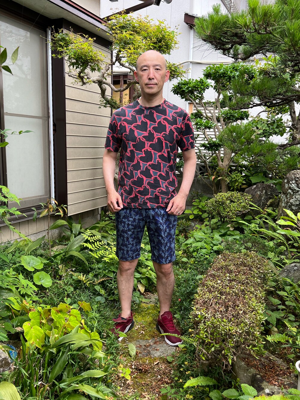 ブラック系のTシャツ/カットソー、ブルー系のパンツ、レッド系のスニーカーを着用したメンズの夏コーディネートの2枚目の写真