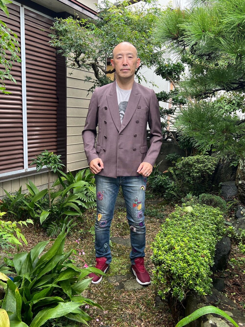 ブラウン系のテーラードジャケット、グレー系のTシャツ/カットソー、ブルー系のデニムパンツを着用したメンズの秋コーディネートの2枚目の写真