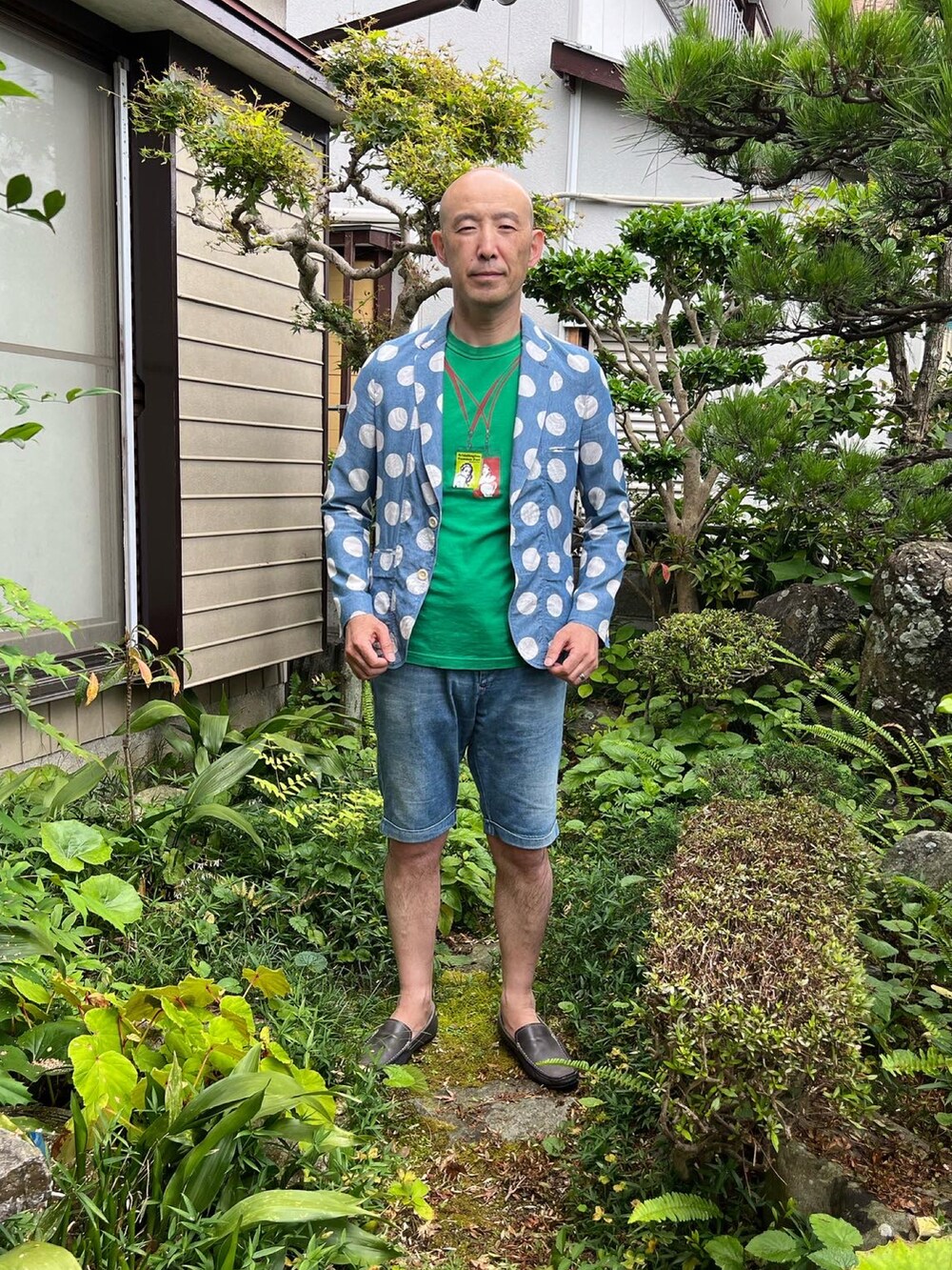 ブルー系のデニムパンツ、ブルー系のテーラードジャケット、グリーン系のTシャツ/カットソーを着用したメンズの夏コーディネートの2枚目の写真