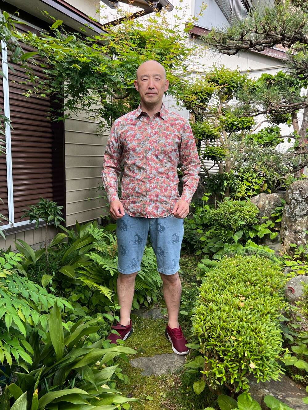 ブルー系のシャツ/ブラウス、グレー系のパンツ、レッド系のスニーカーを着用したメンズの春コーディネートの2枚目の写真