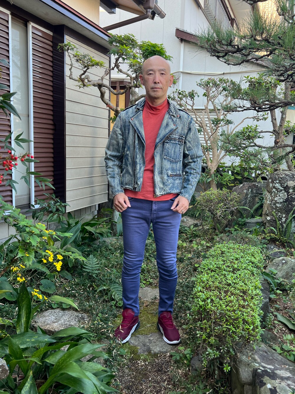 ブルー系のライダースジャケット、オレンジ系のTシャツ/カットソー、ブルー系のデニムパンツを着用したメンズの秋コーディネートの2枚目の写真