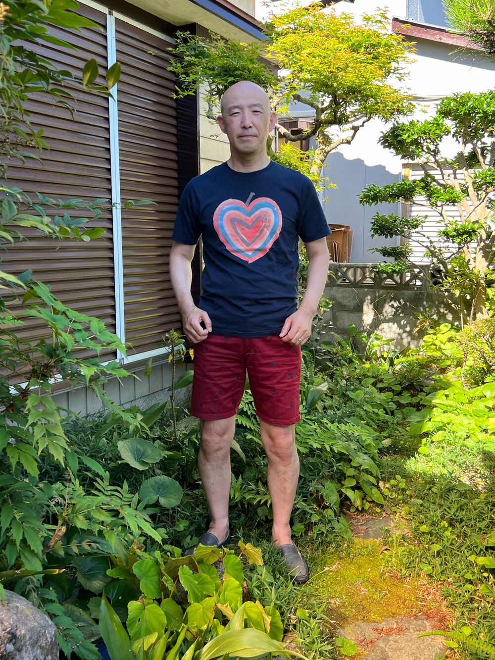 ブラック系のTシャツ/カットソー、レッド系のパンツを着用したメンズの夏コーディネートの2枚目の写真