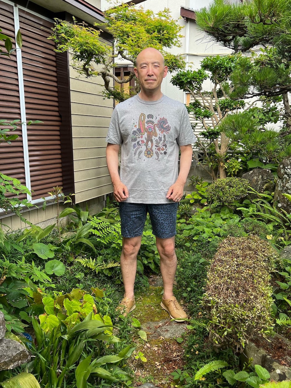グレー系のTシャツ/カットソー、ブルー系のパンツ、ベージュ系のスニーカーを着用したメンズの夏コーディネートの2枚目の写真
