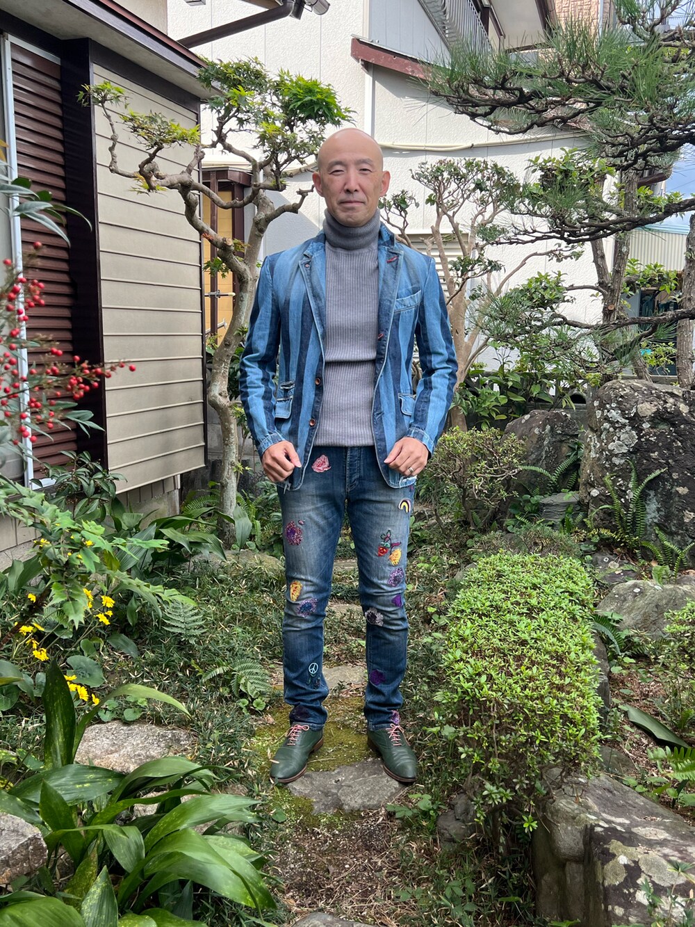 ブルー系のデニムパンツ、ブルー系のデニムジャケット、グレー系のニット/セーターを着用したメンズの秋コーディネートの2枚目の写真