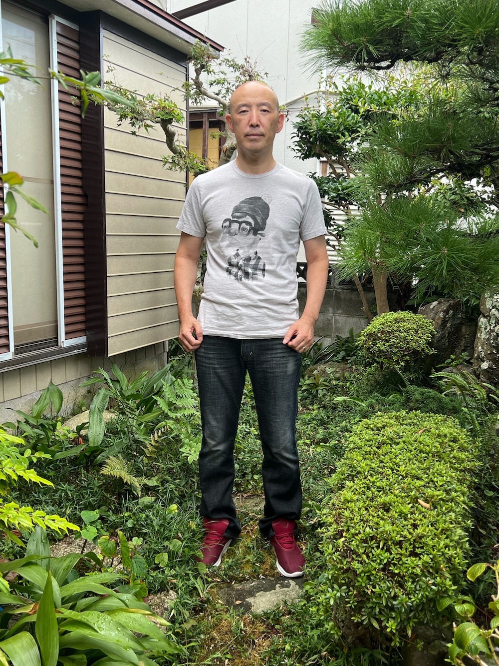 グレー系のTシャツ/カットソー、ブラック系のデニムパンツ、レッド系のスニーカーを着用したメンズの秋コーディネートの2枚目の写真