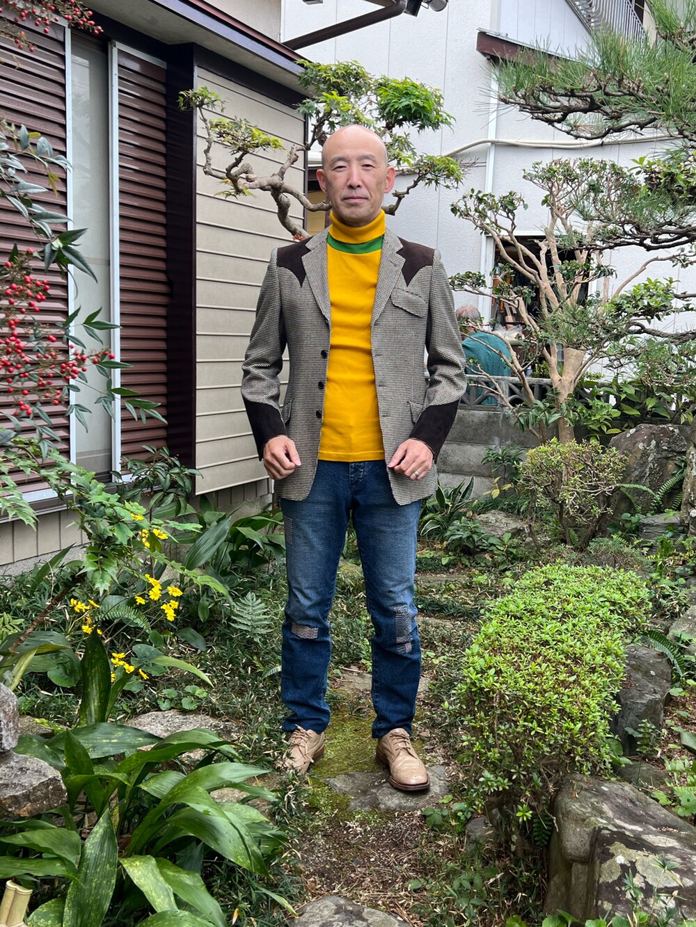 レッド系のテーラードジャケット、ベージュ系のテーラードジャケット、ブルー系のデニムパンツを着用したメンズの秋コーディネートの2枚目の写真