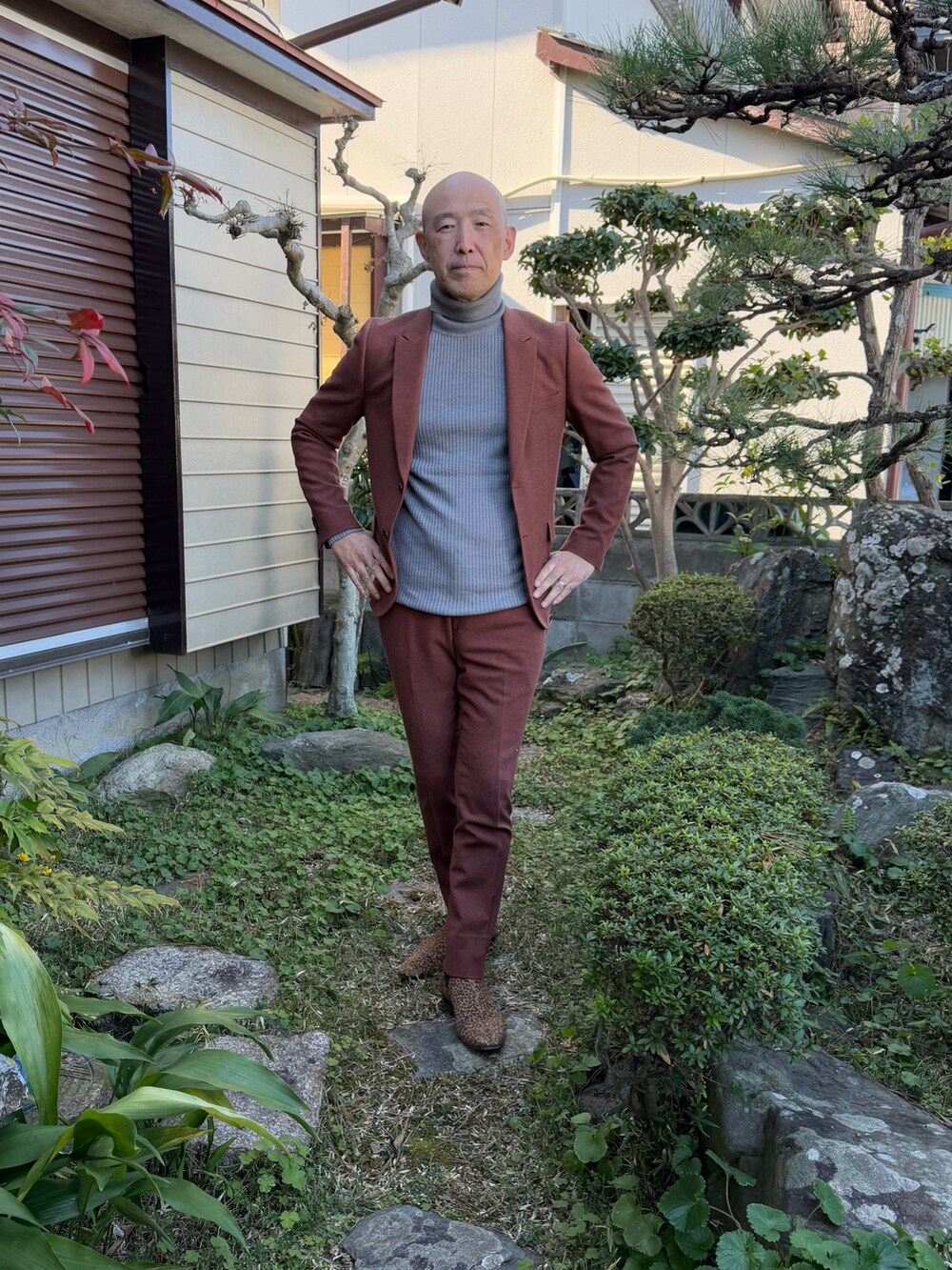 グレー系のニット/セーター、ブラウン系のパンツ、ブラウン系のテーラードジャケットを着用したメンズの冬コーディネートの2枚目の写真