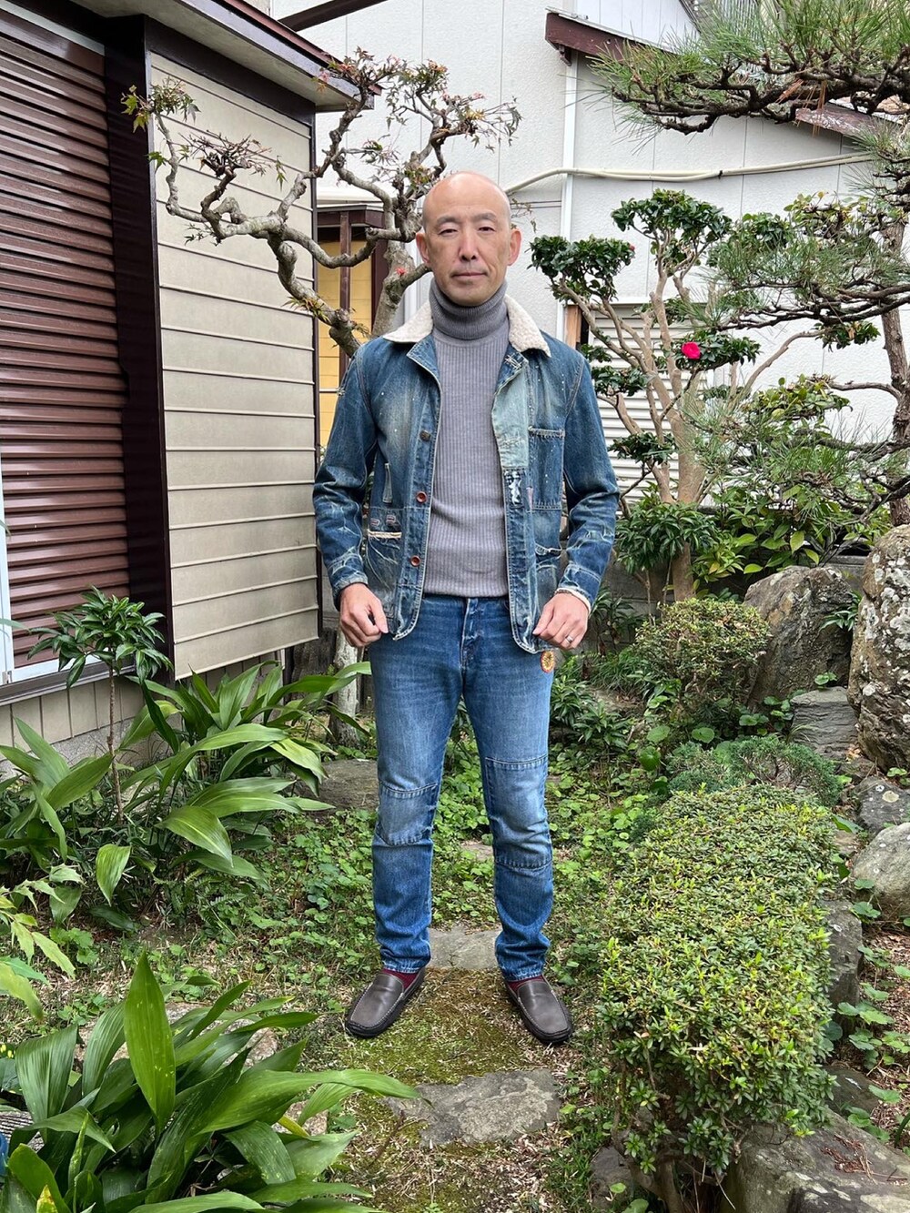 ブルー系のデニムジャケット、グレー系のニット/セーター、ブルー系のデニムパンツを着用したメンズの冬コーディネートの2枚目の写真