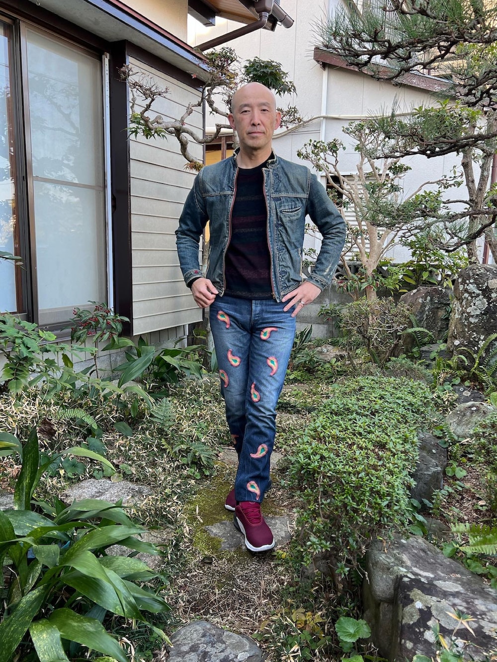 ブラック系のニット/セーター、ブルー系のライダースジャケット、ブルー系のデニムパンツを着用したメンズの冬コーディネートの2枚目の写真