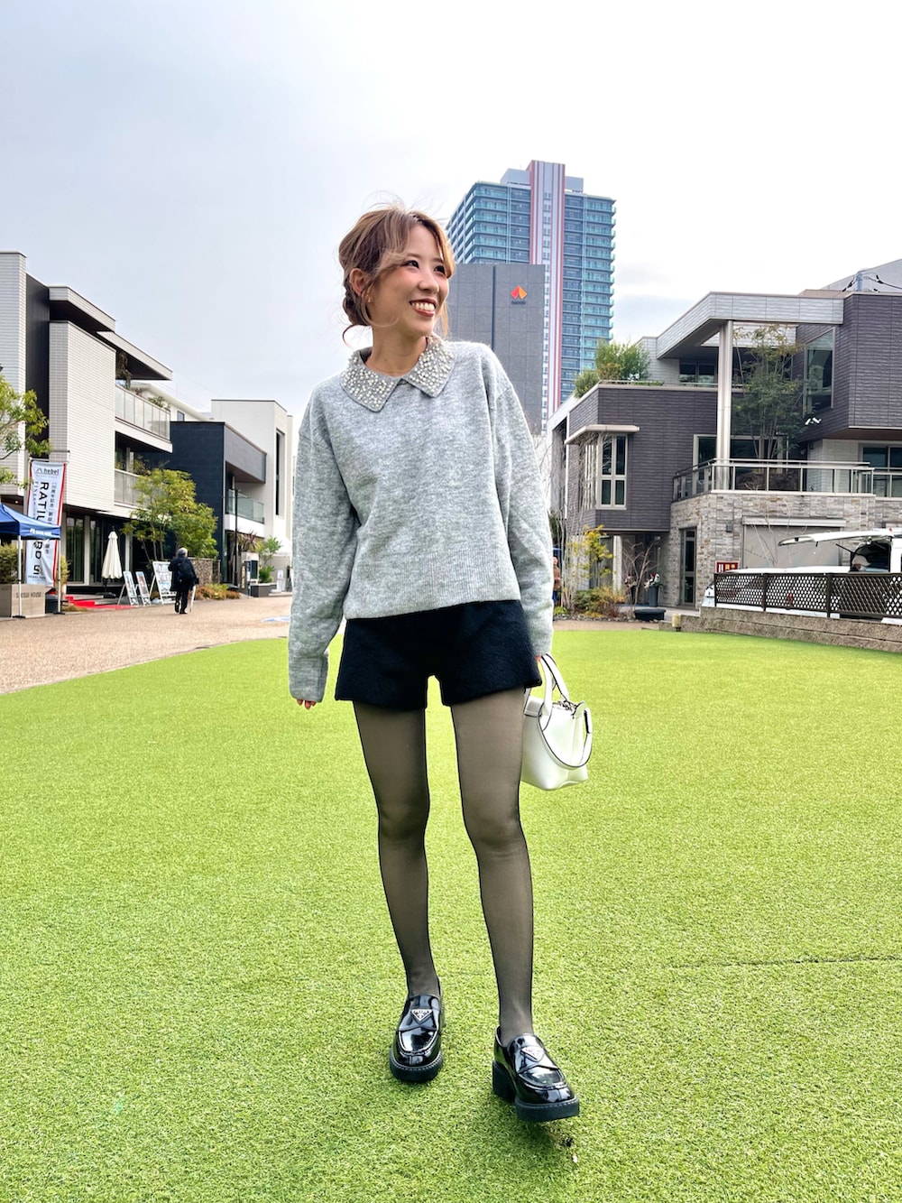 ブラック系のローファー、ホワイト系のショルダーバッグ、ブラック系のその他パンツを着用したレディースの冬コーディネートの2枚目の写真