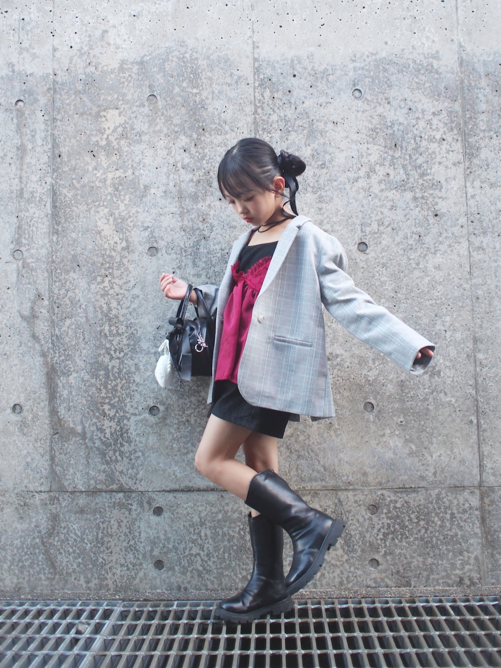 レッド系のキャミソール、グレー系のテーラードジャケット、ブラック系のその他パンツを着用したキッズの秋コーディネートの2枚目の写真