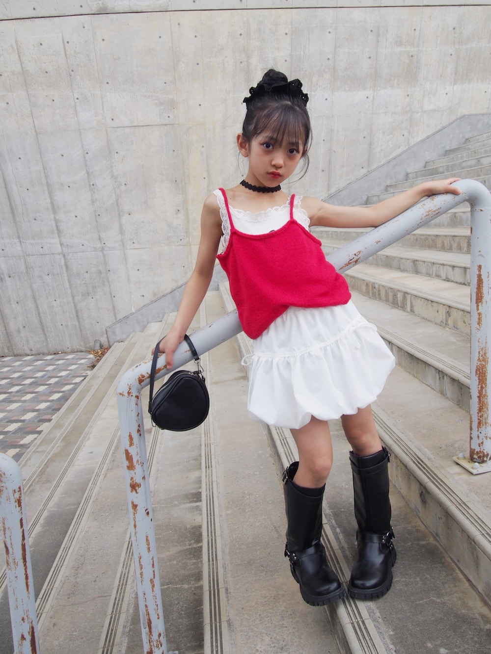 レッド系のキャミソール、ホワイト系のスカートを着用したキッズの夏コーディネートの2枚目の写真