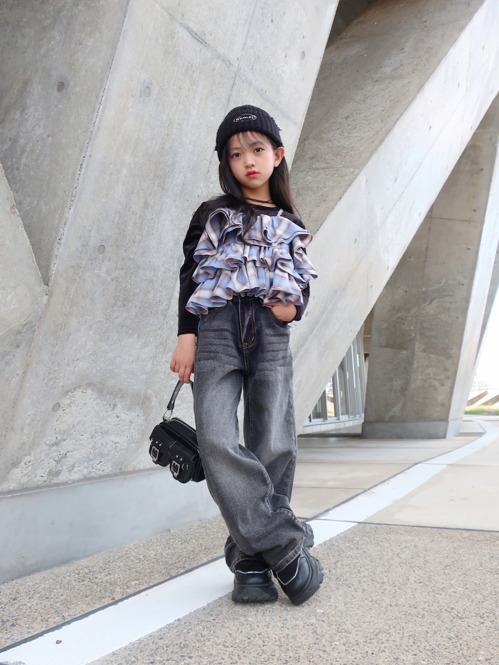 ブルー系のキャミソール、ブラック系のデニムパンツを着用したキッズの秋コーディネートの2枚目の写真