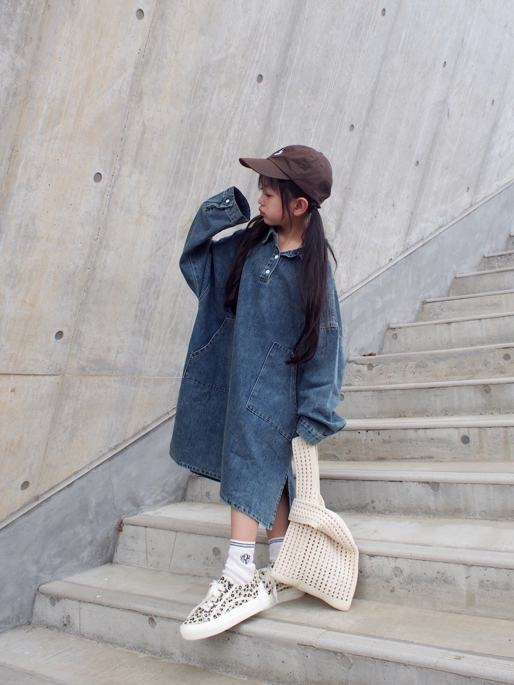 ブルー系のワンピース/ドレス、ブラウン系のキャップを着用したキッズの秋コーディネートの2枚目の写真