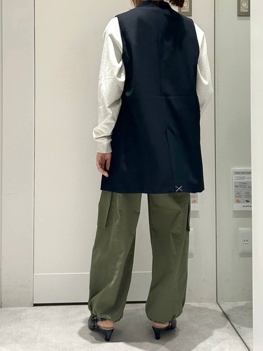 グリーン系のカーゴパンツ、グレー系のTシャツ/カットソー、ブルー系のベストを着用したレディースの冬コーディネートの3枚目の写真