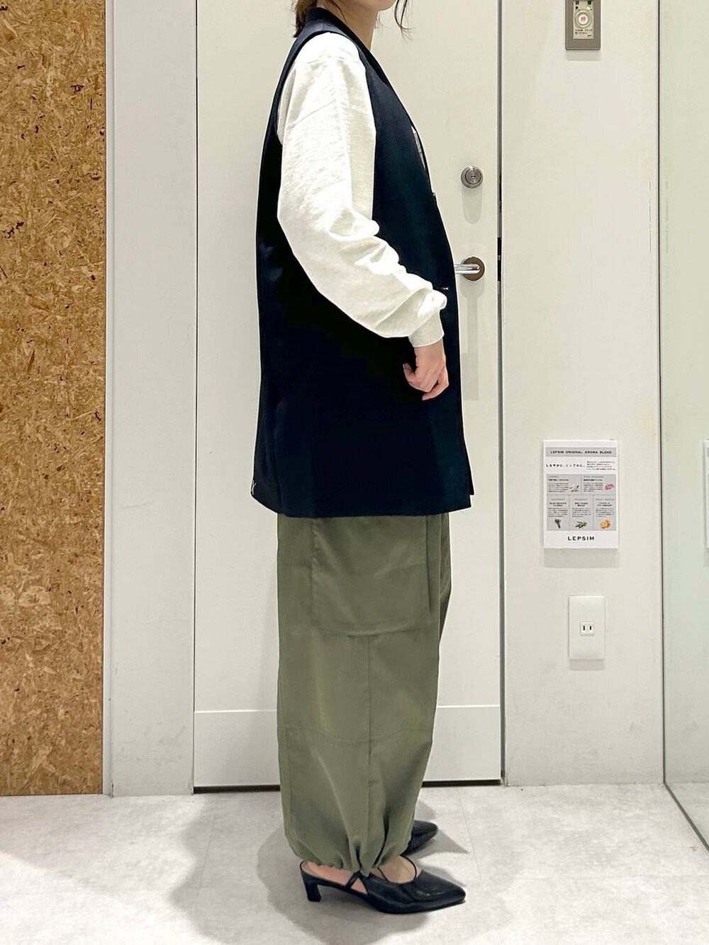 グリーン系のカーゴパンツ、グレー系のTシャツ/カットソー、ブルー系のベストを着用したレディースの冬コーディネートの2枚目の写真