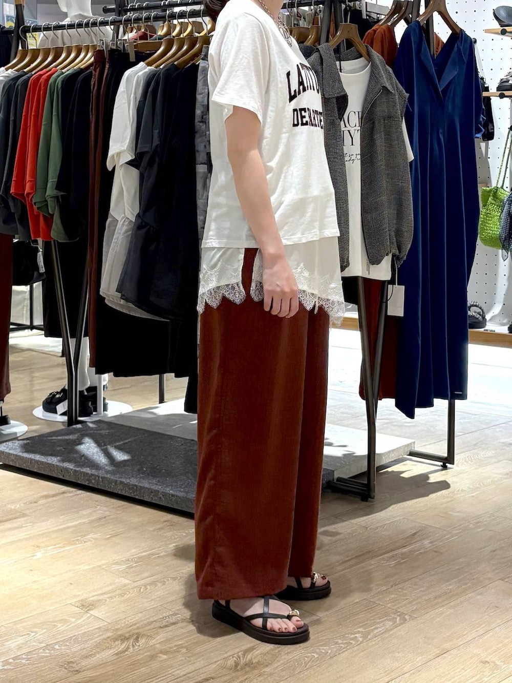 ブラウン系のサンダル、ブラウン系のその他パンツ、ホワイト系のキャミソールを着用したレディースの春コーディネートの2枚目の写真
