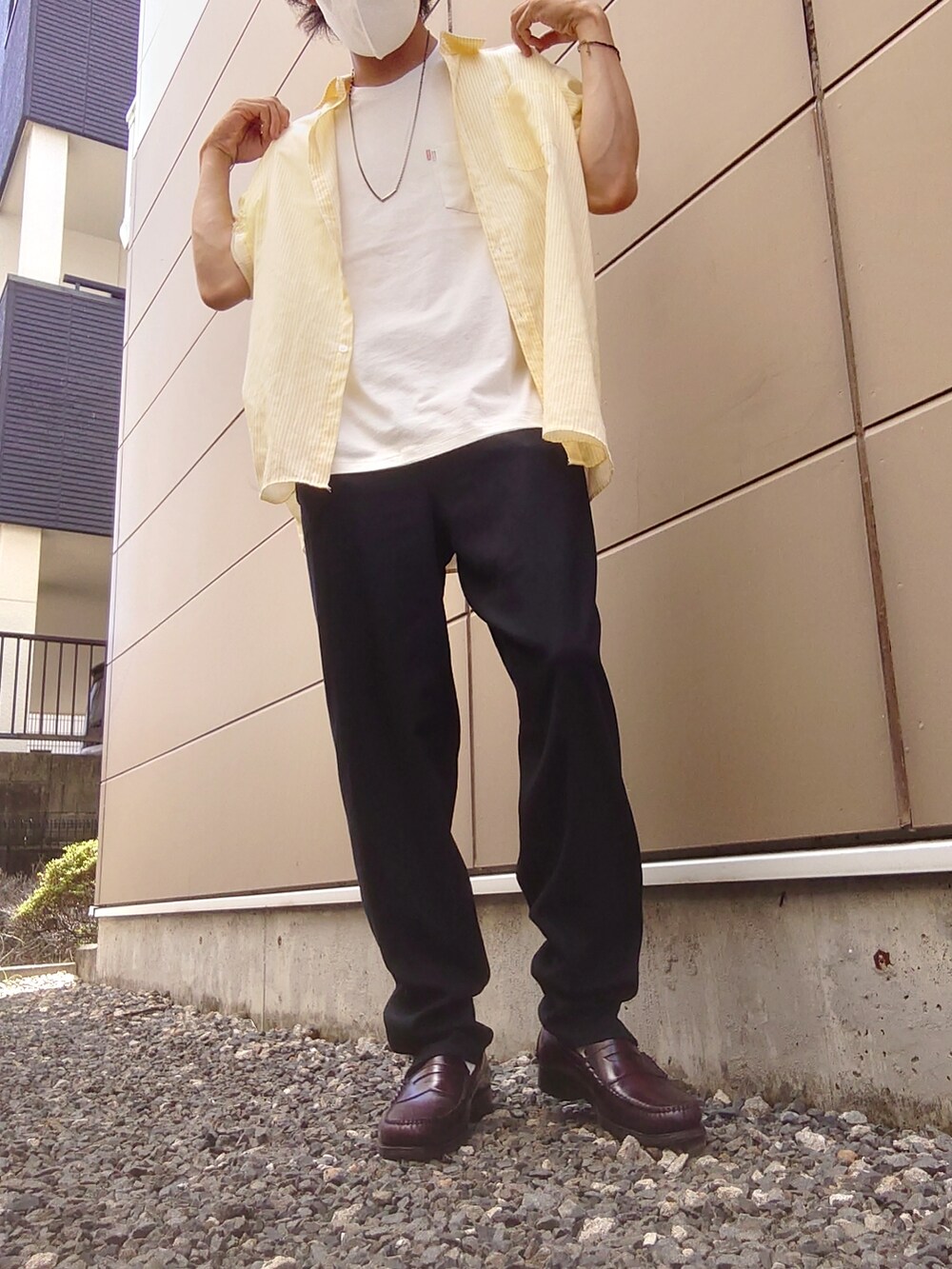 ブラック系のスラックス、イエロー系のシャツ/ブラウス、ホワイト系のTシャツ/カットソーを着用したメンズの夏コーディネートの2枚目の写真