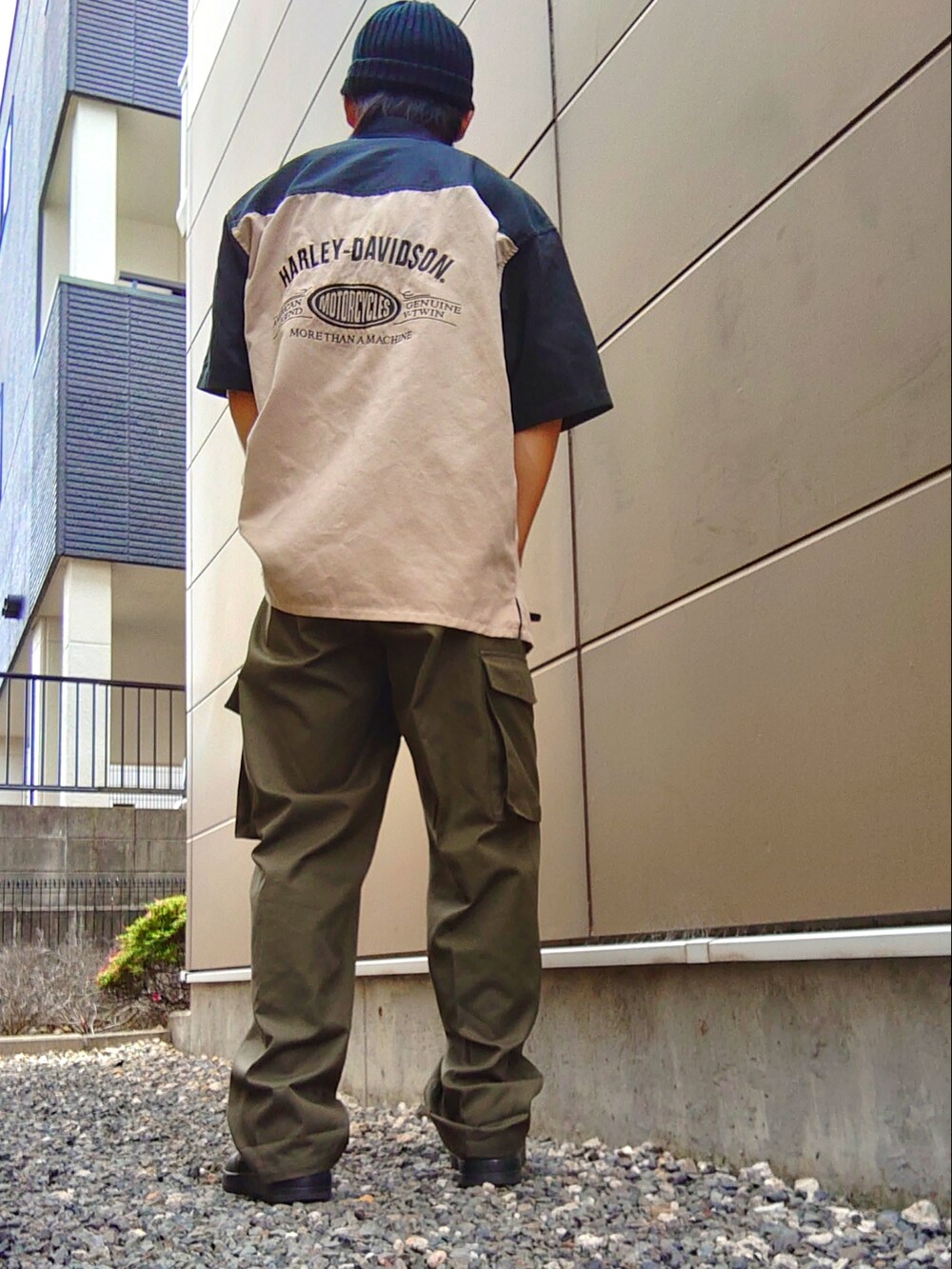 ベージュ系のシャツ/ブラウス、グリーン系のカーゴパンツ、ブラック系のスニーカーを着用したメンズの夏コーディネートの2枚目の写真