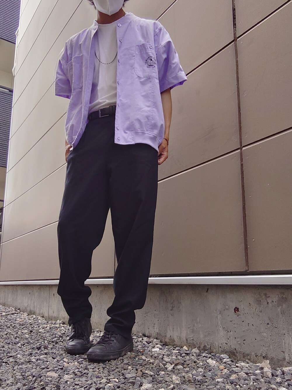 ブラック系のスラックス、パープル系のトップス、ホワイト系のポロシャツを着用したメンズの夏コーディネートの2枚目の写真