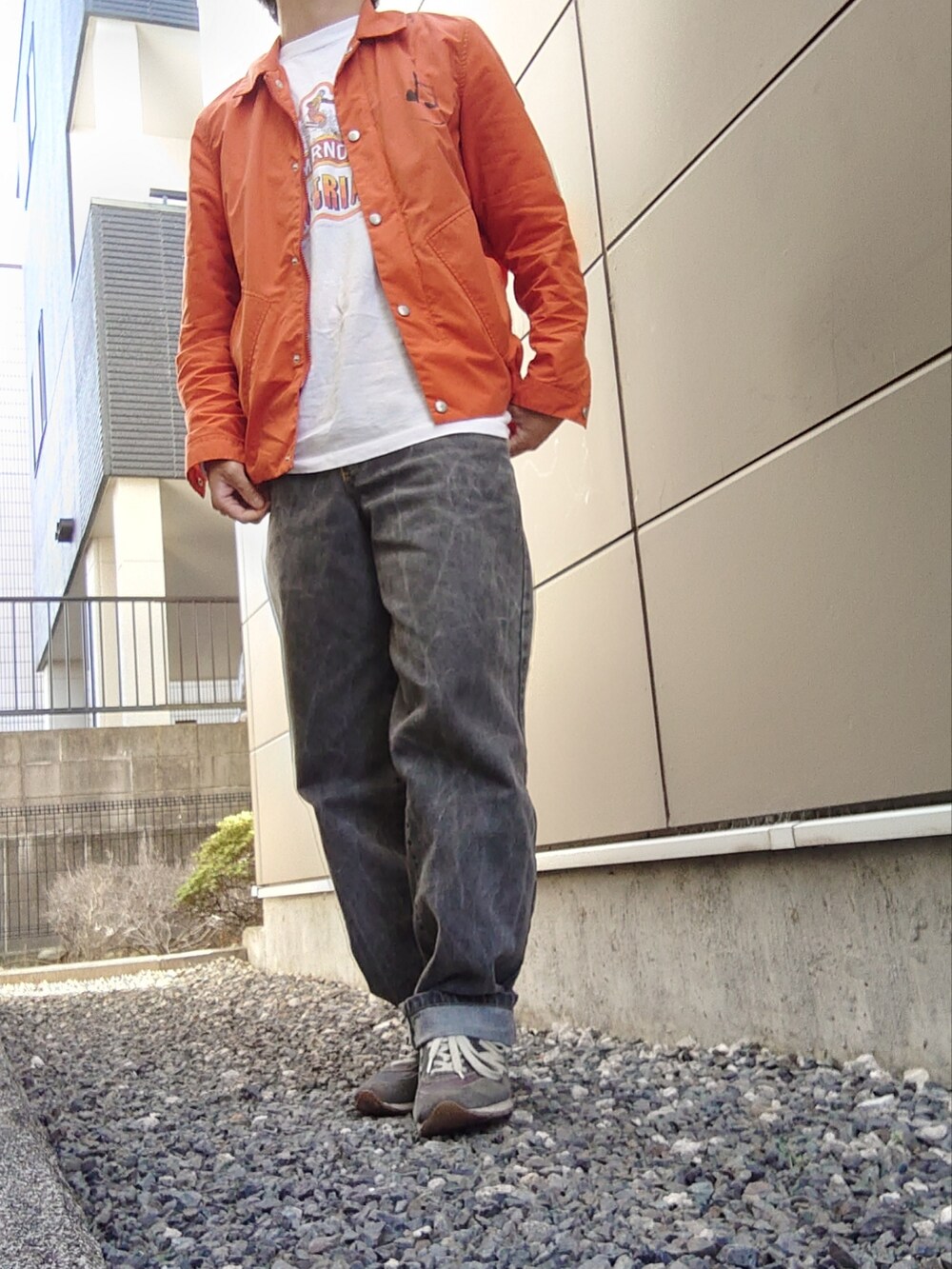 ホワイト系のTシャツ/カットソー、ピンク系のスウェット、オレンジ系のナイロンジャケットを着用したメンズの春コーディネートの2枚目の写真