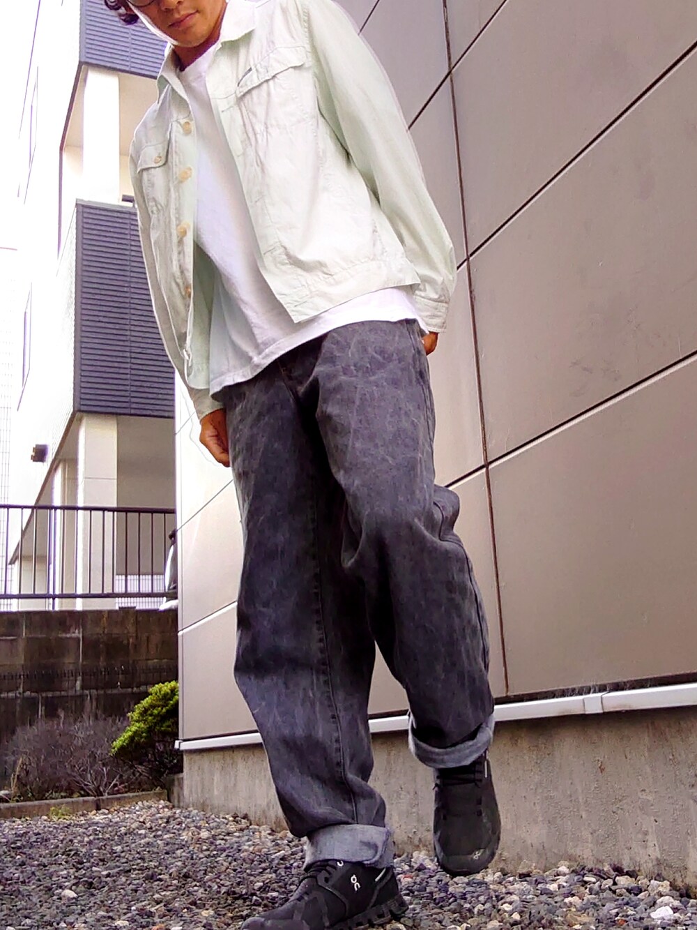 グレー系のデニムパンツ、グリーン系のジャケット/アウター、ブラック系のスニーカーを着用したメンズの秋コーディネートの2枚目の写真