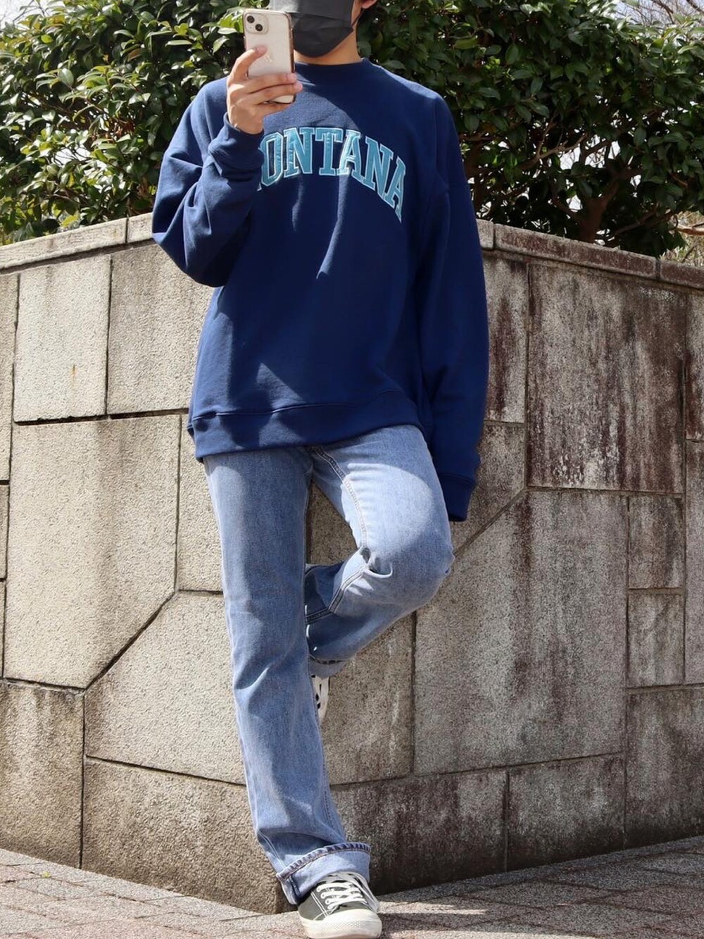 ブルー系のスウェット、ブルー系のデニムパンツ、ブラック系のシューズを着用したメンズの春コーディネートの2枚目の写真