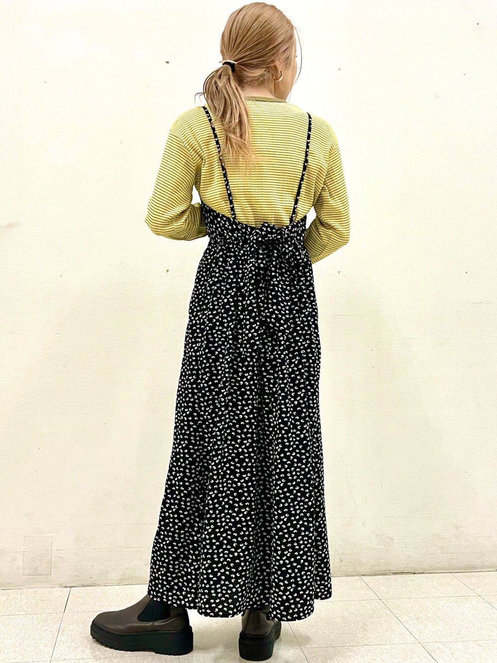 イエロー系のTシャツ/カットソー、ブラック系のワンピースを着用したレディースの春コーディネートの2枚目の写真