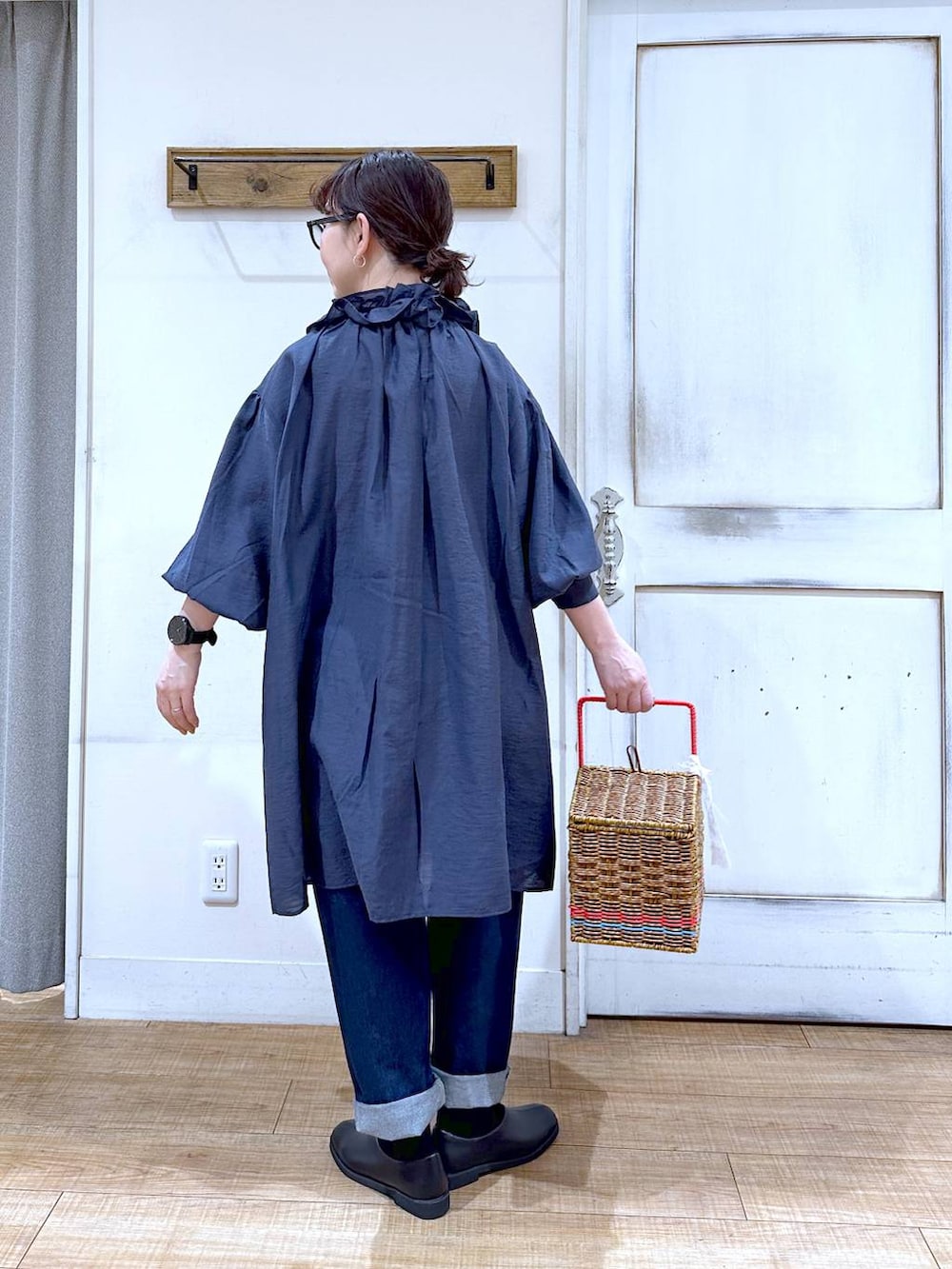 ブルー系のデニムパンツ、ブラック系のスリッポン、ブルー系のワンピースを着用したレディースの春コーディネートの3枚目の写真