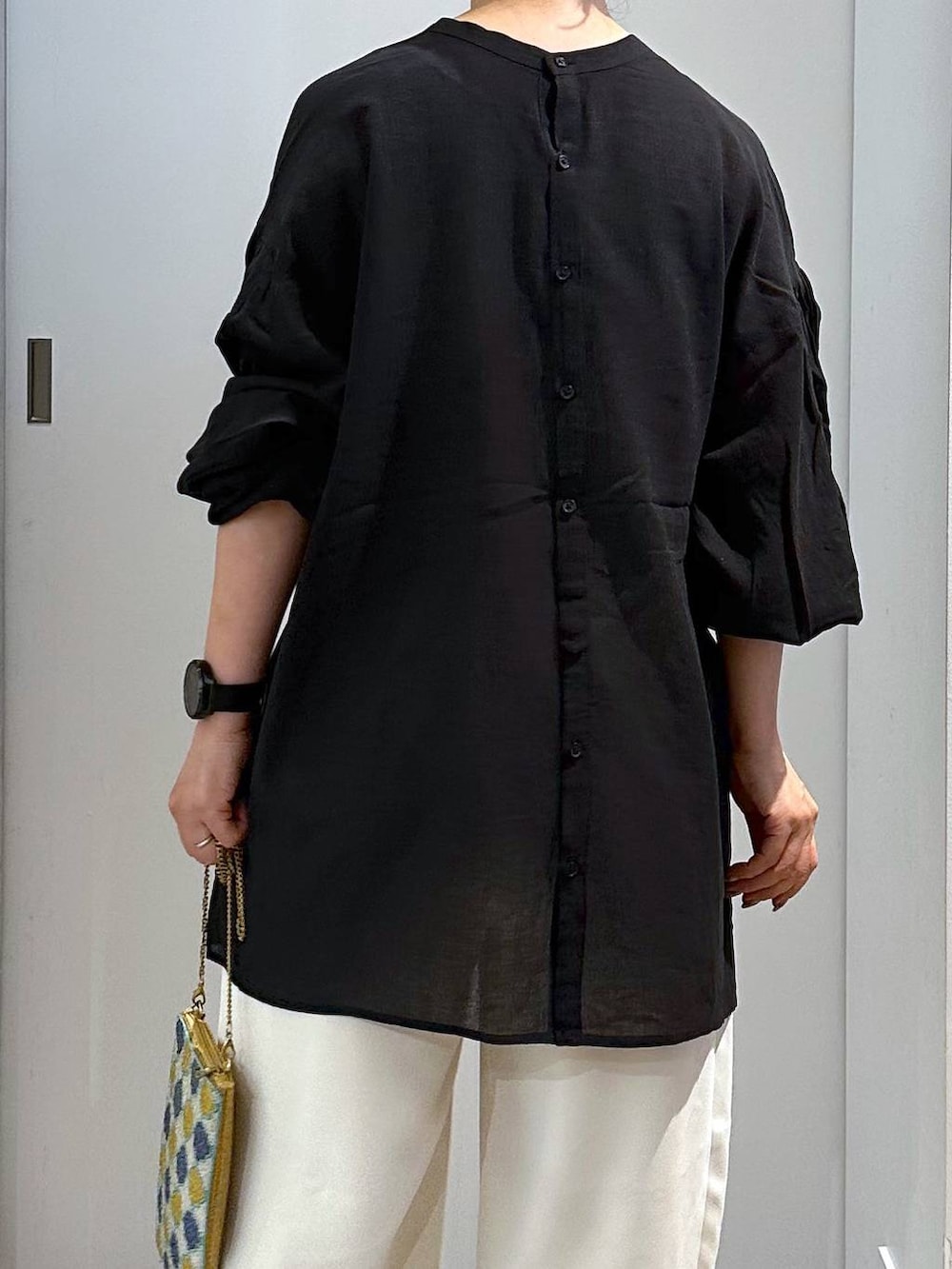 ブルー系のショルダーバッグ、ベージュ系のスラックスを着用したレディースの夏コーディネートの4枚目の写真