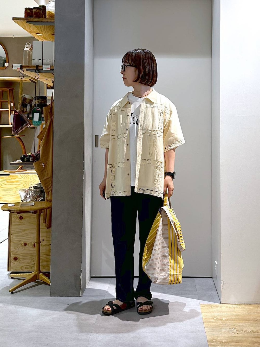 ホワイト系のTシャツ/カットソー、ブルー系のデニムパンツ、イエロー系のトートバッグを着用したレディースの夏コーディネートの4枚目の写真