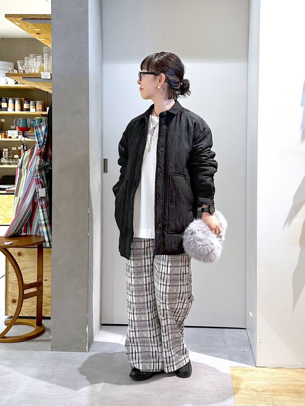 グレー系のハンドバッグ、ホワイト系のTシャツ/カットソー、ブラック系のその他パンツを着用したレディースの秋コーディネートの2枚目の写真