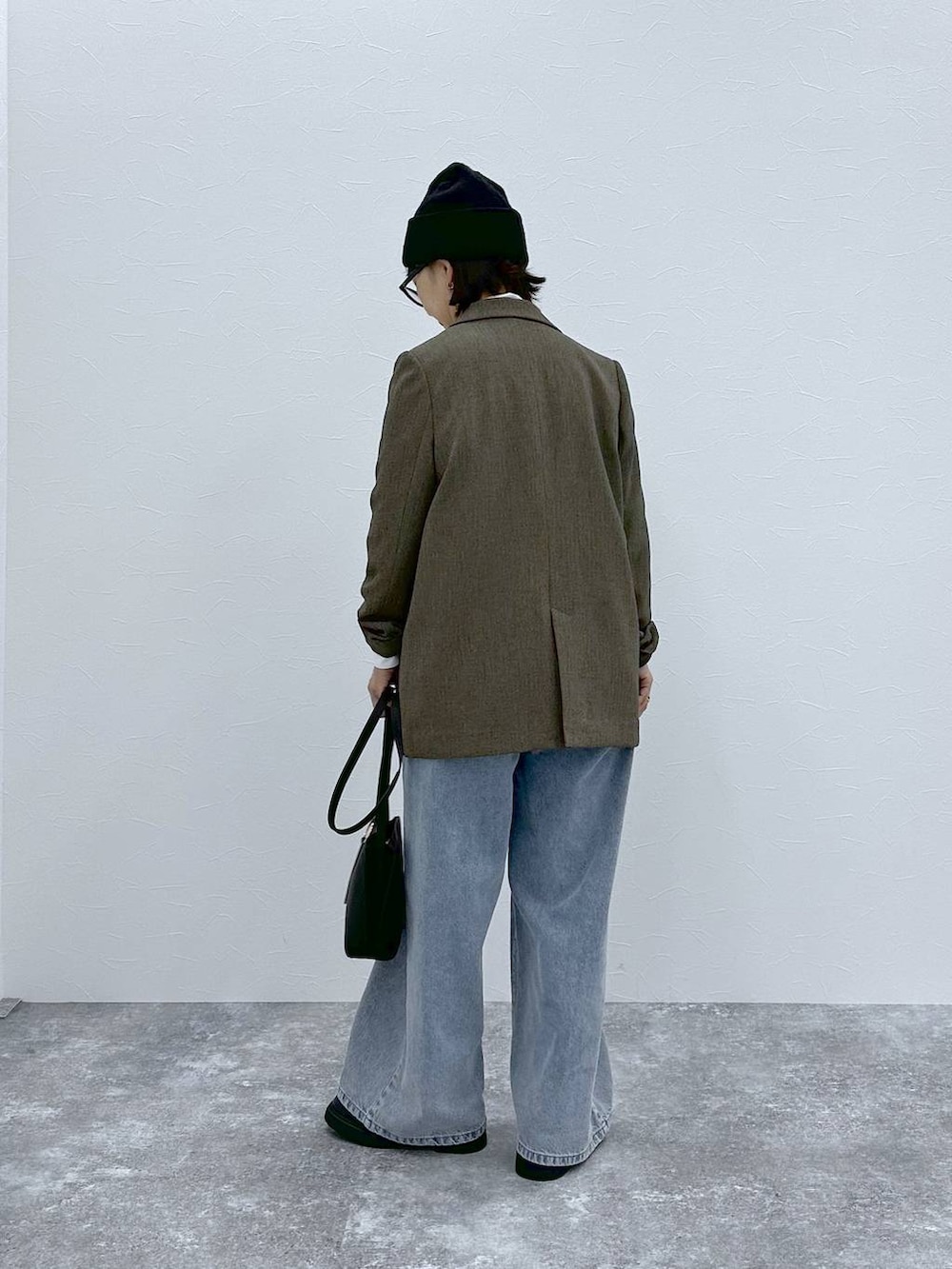 ブラウン系のテーラードジャケット、ホワイト系のTシャツ/カットソー、ブラック系のショルダーバッグを着用したレディースの秋コーディネートの4枚目の写真