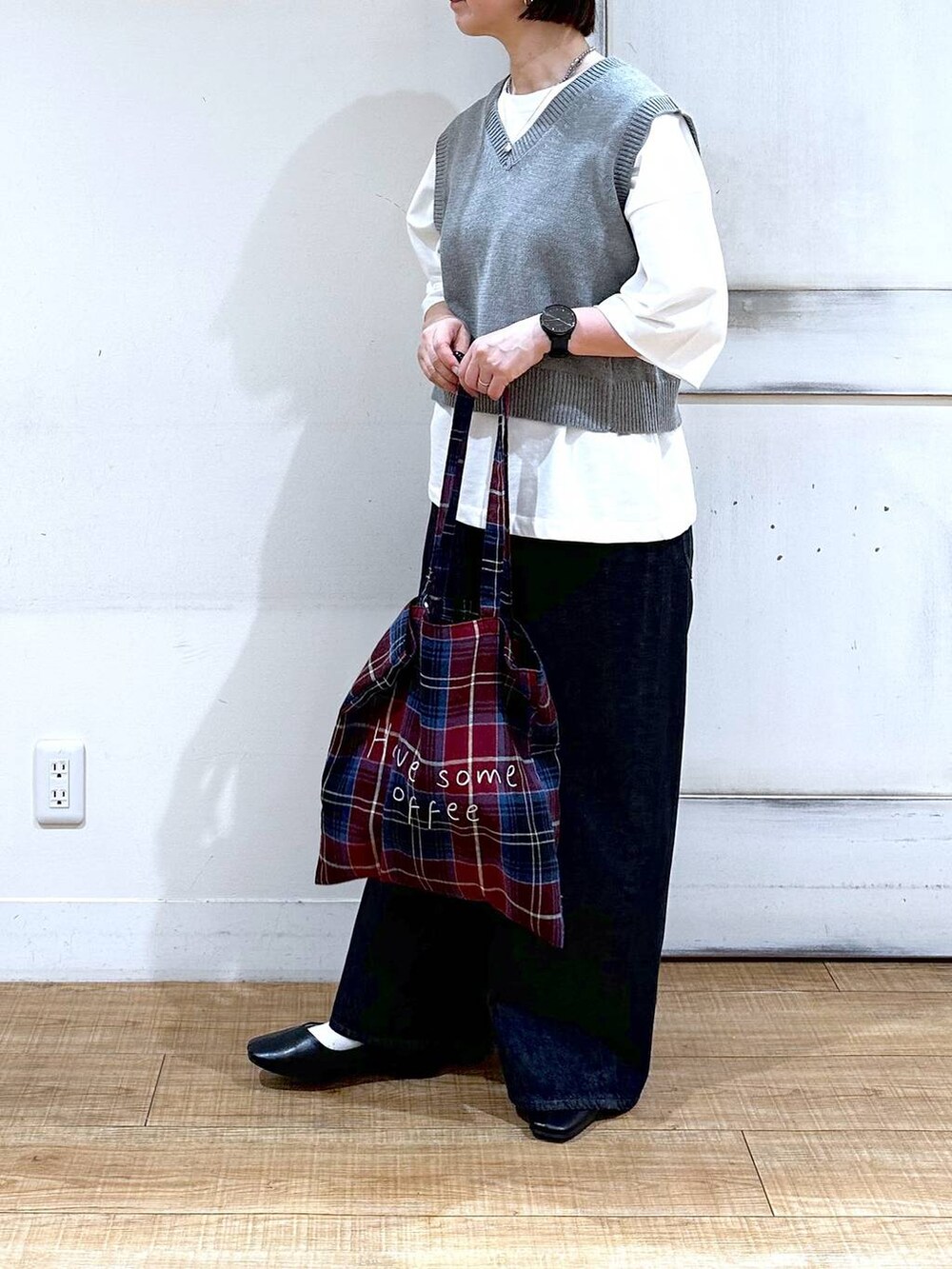 ホワイト系のTシャツ/カットソー、グレー系のベスト、ブラック系のパンプスを着用したレディースの秋コーディネートの5枚目の写真