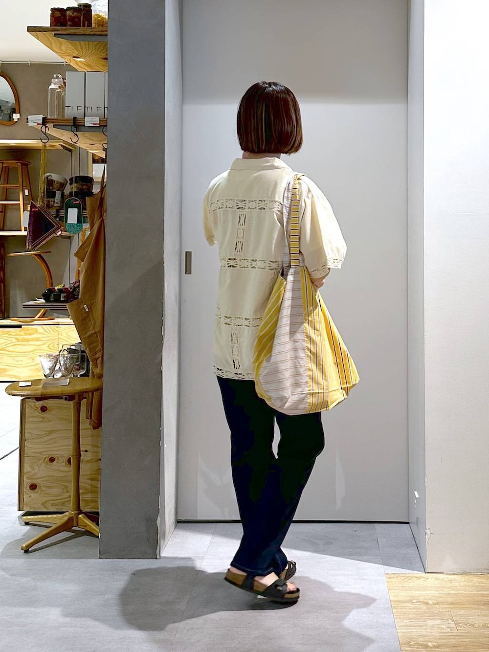 ホワイト系のTシャツ/カットソー、ブルー系のデニムパンツ、イエロー系のトートバッグを着用したレディースの夏コーディネートの3枚目の写真