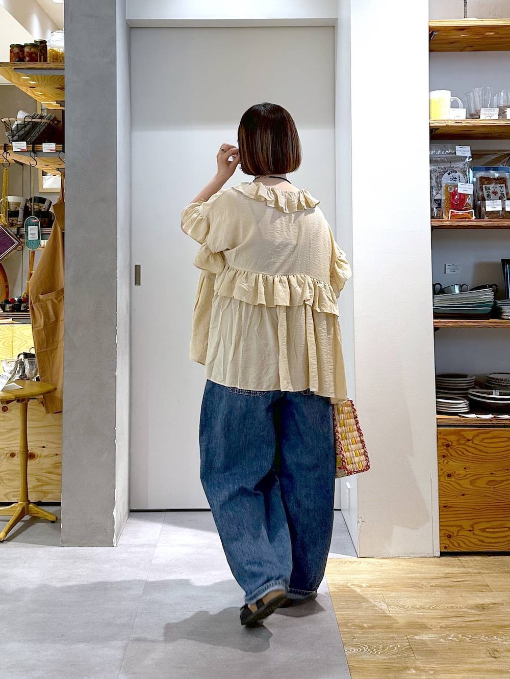 ブルー系のデニムパンツ、ベージュ系のシャツ/ブラウス、イエロー系のかごバッグを着用したレディースの夏コーディネートの5枚目の写真