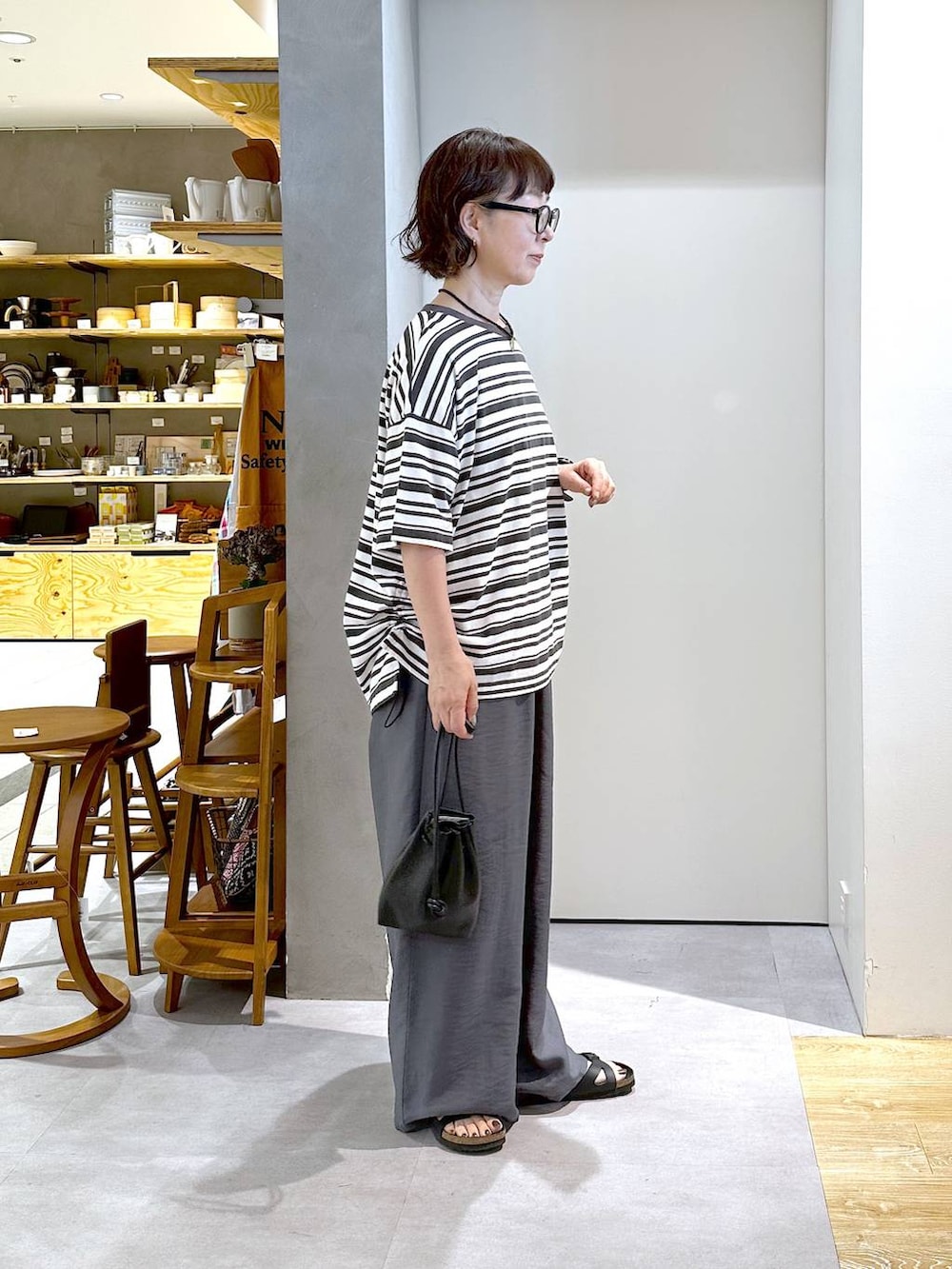 ブラック系のショルダーバッグ、グレー系のTシャツ/カットソー、グレー系のその他パンツを着用したレディースの夏コーディネートの4枚目の写真