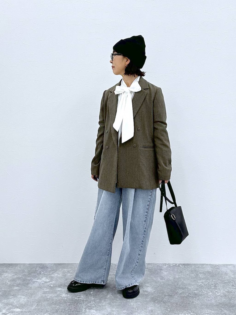 ブラウン系のテーラードジャケット、ホワイト系のTシャツ/カットソー、ブラック系のショルダーバッグを着用したレディースの秋コーディネートの2枚目の写真