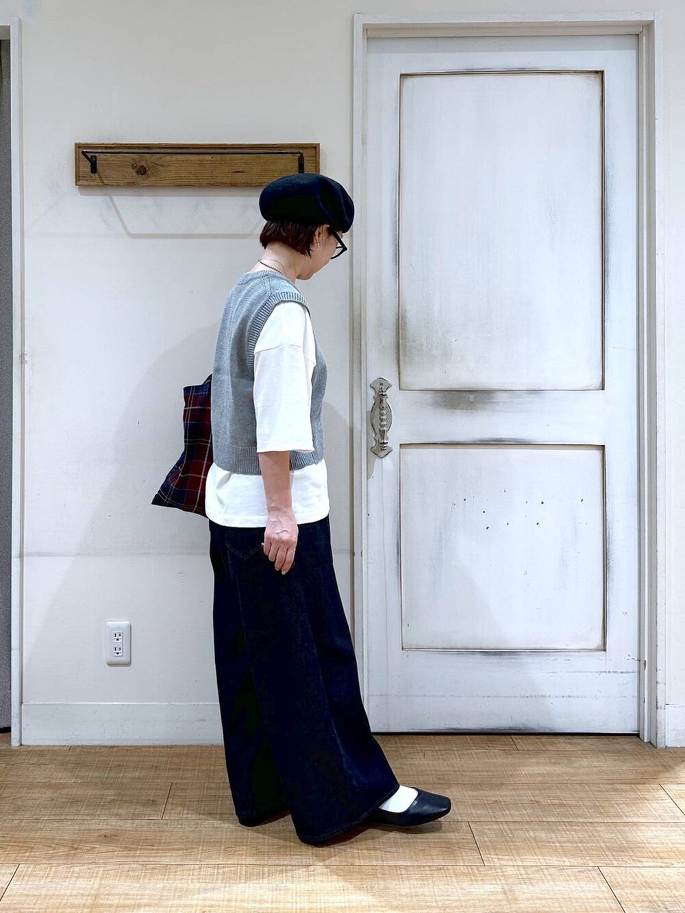 ホワイト系のTシャツ/カットソー、グレー系のベスト、ブラック系のパンプスを着用したレディースの秋コーディネートの3枚目の写真