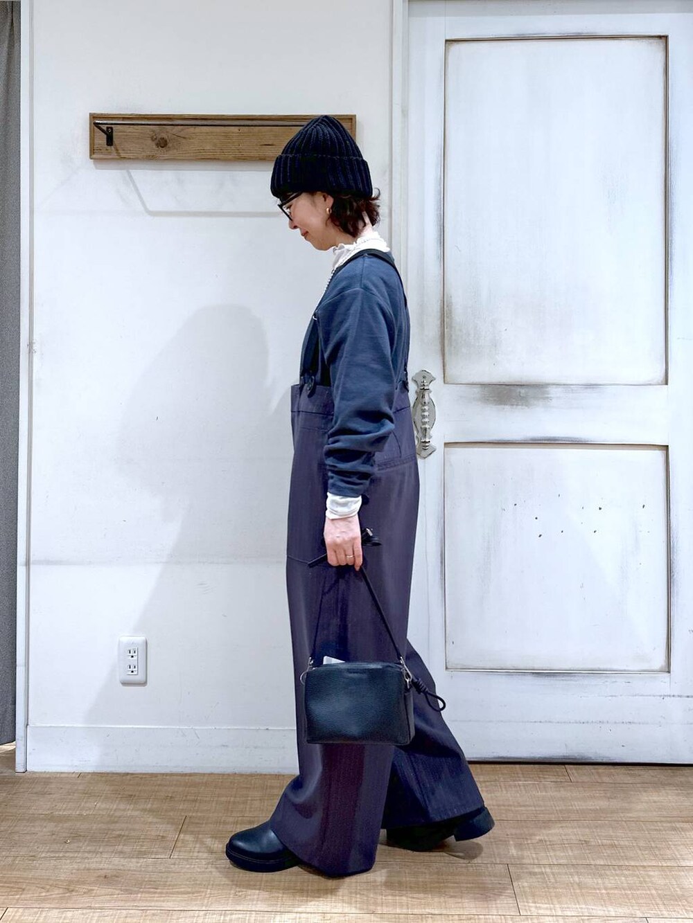 ブラック系のブーツ、ブラック系のショルダーバッグ、ホワイト系のTシャツ/カットソーを着用したレディースの冬コーディネートの2枚目の写真