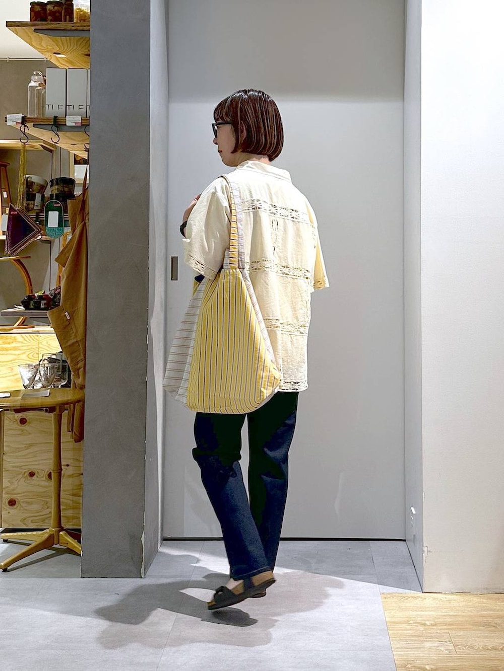 ホワイト系のTシャツ/カットソー、ブルー系のデニムパンツ、イエロー系のトートバッグを着用したレディースの夏コーディネートの2枚目の写真