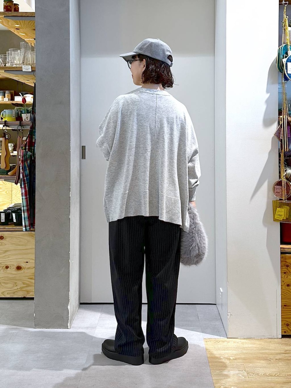 グレー系のハンドバッグ、ブラック系のブーツ、グレー系のカーディガン/ボレロを着用したレディースの秋コーディネートの3枚目の写真