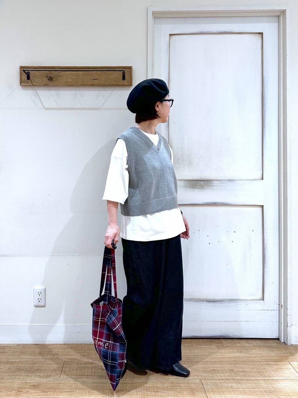 ホワイト系のTシャツ/カットソー、グレー系のベスト、ブラック系のパンプスを着用したレディースの秋コーディネートの4枚目の写真