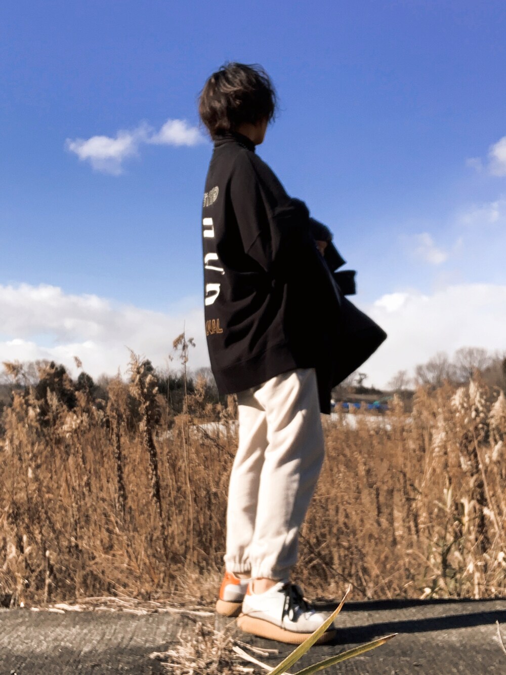 ブラック系のジャケット/アウター、ホワイト系のスウェットパンツ、ホワイト系のスニーカーを着用したレディースの冬コーディネートの3枚目の写真