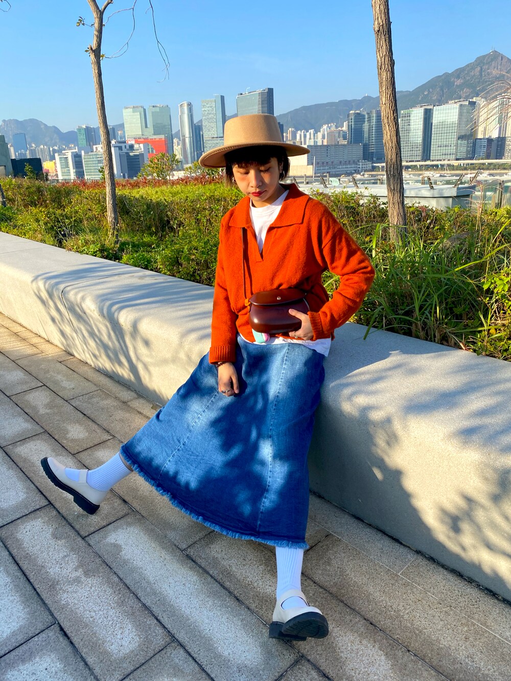 オレンジ系のトップス、ベージュ系のローファーを着用したレディースの秋コーディネートの2枚目の写真