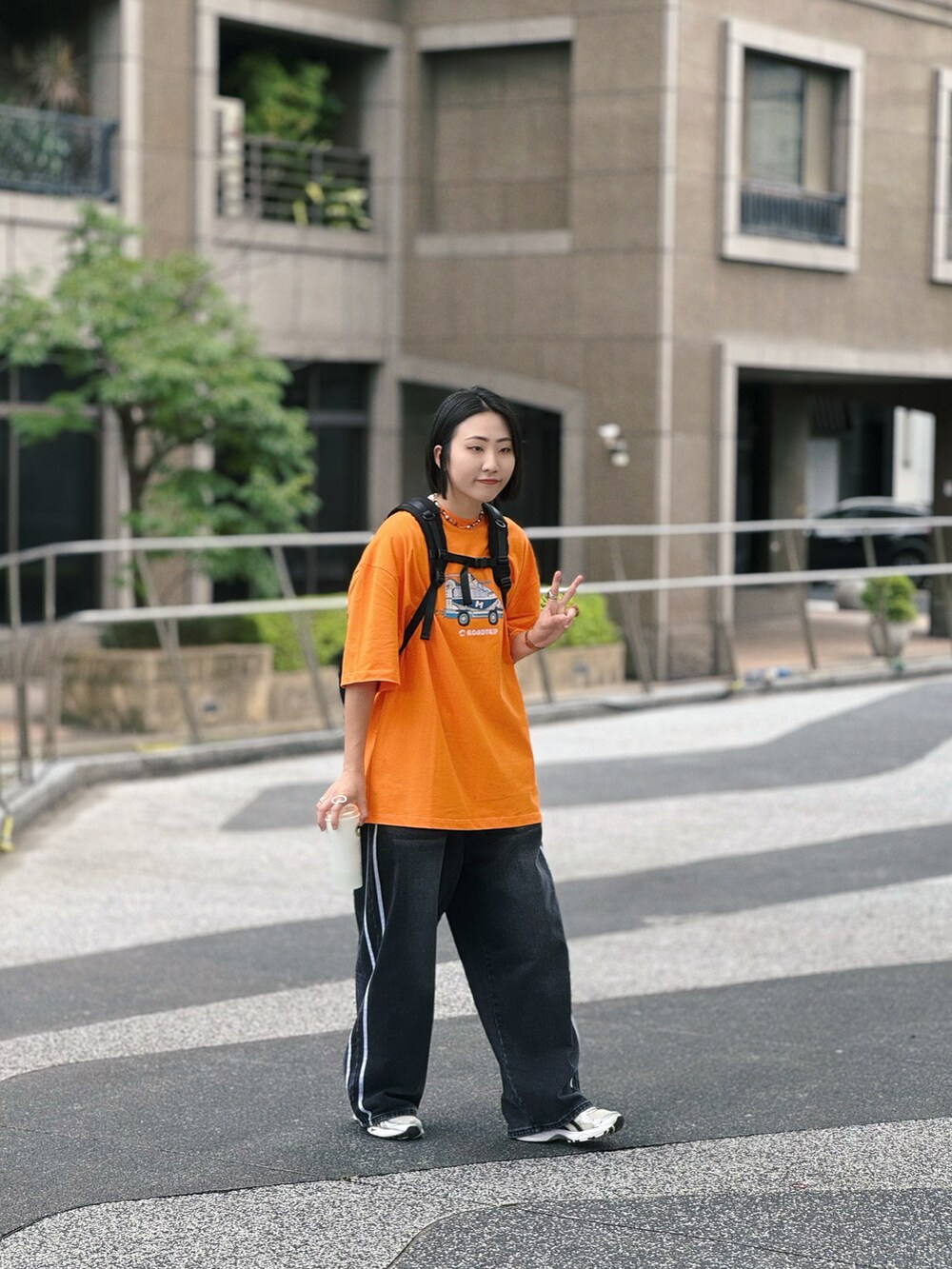 ブラック系のデニムパンツ、シルバー系のスニーカーを着用したレディースの夏コーディネートの3枚目の写真