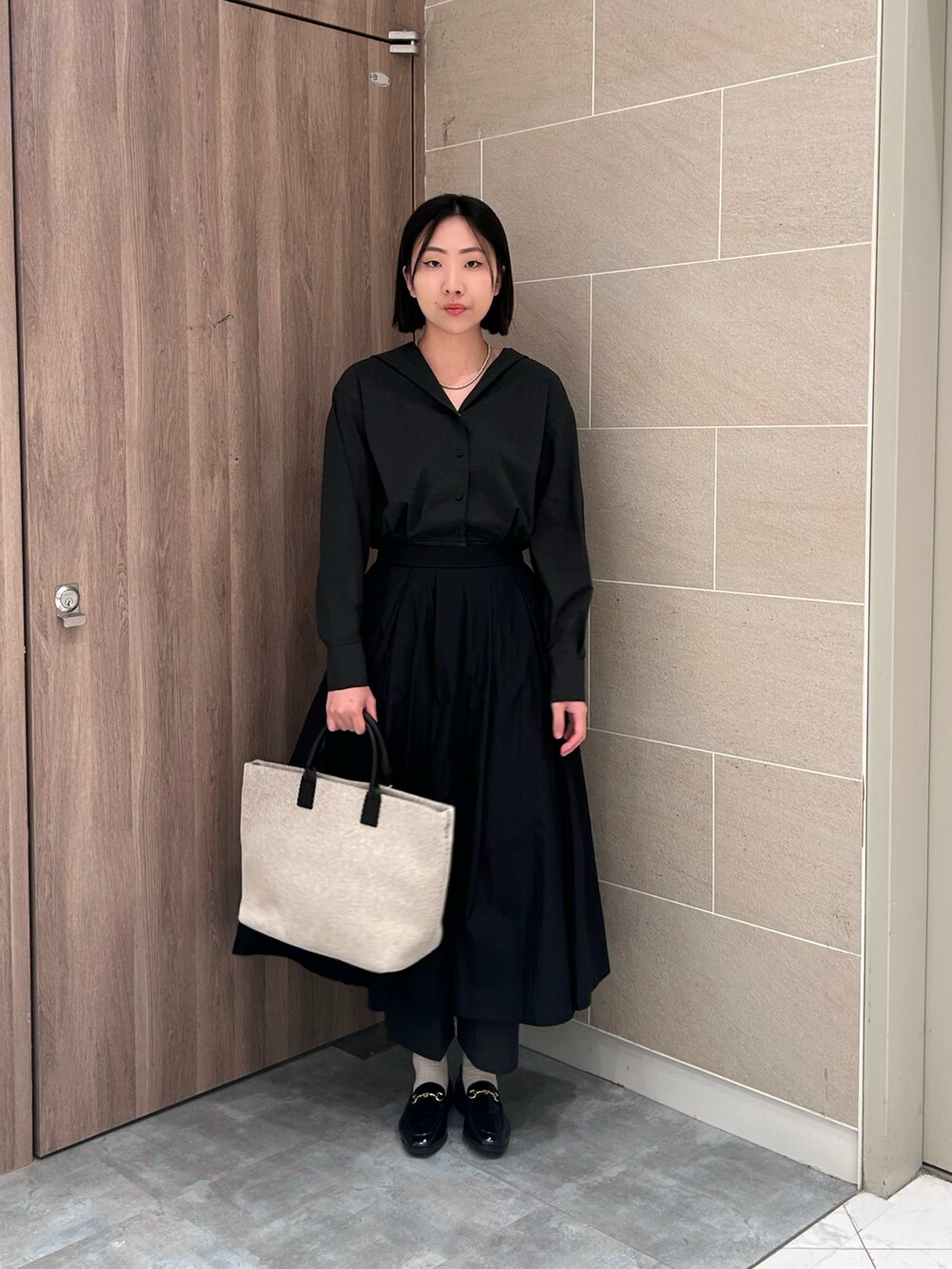 ブラック系のオールインワン・サロペットを着用したレディースの秋コーディネートの3枚目の写真