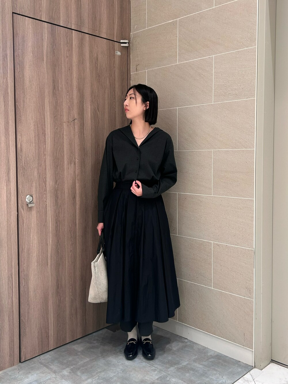 ブラック系のオールインワン・サロペットを着用したレディースの秋コーディネートの2枚目の写真